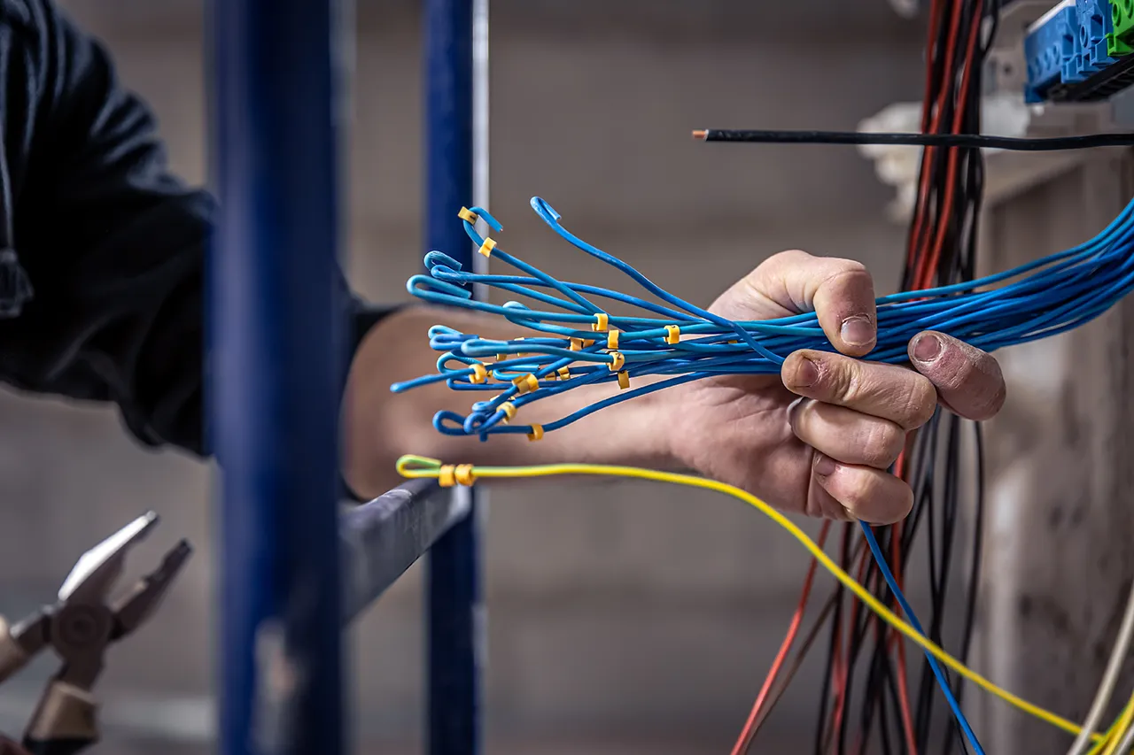 Electrician works switchboard